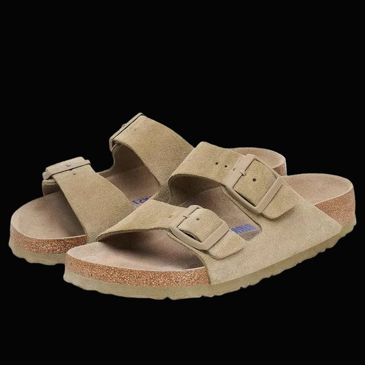 Pair of tan sandals with double straps on a white background